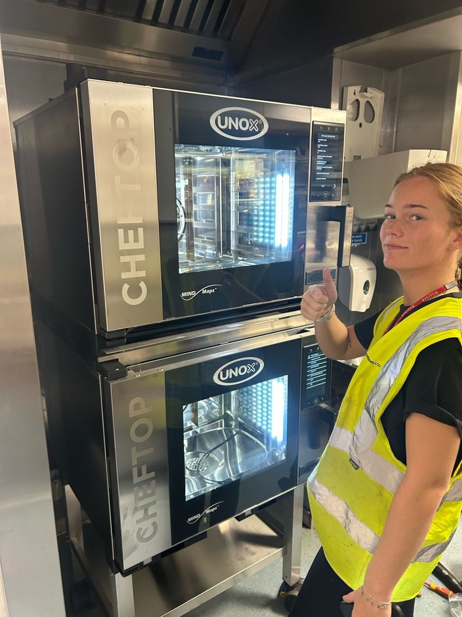 Engineer performing maintenance on commercial kitchen equipment